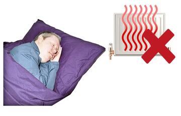 A man asleep in bed.  Behind him is a radiator with a red cross beside it.