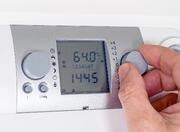 a thermostat with a hand turning a dial