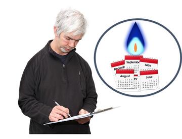A man holding a clipboard and signing something.  Beside the man is a blue circle with a gas flame and some months on a calendar in it.