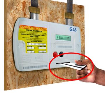 A hand putting a card into a prepayment meter with a red circle around the card.