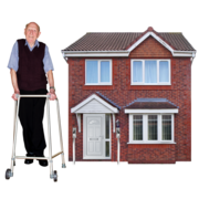 A man using a walking frame is standing outside his house