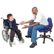 A man is sitting on a chair explaining something to a man in a wheelchair