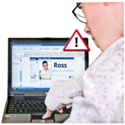 A man using a laptop to talk to someone called Ross online. Above the computer is a safety warning sign.
