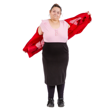 A woman is putting on a red cardigan