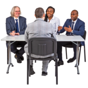 A person is interviewed at a desk by three other people.