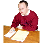 A man sitting at a desk with pen and paper. 