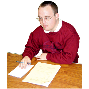 A man sitting at a desk with pen and paper. 