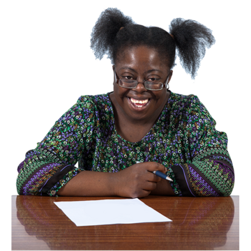 A woman sat a desk writing a letter.