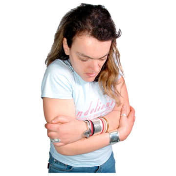 A woman has her arms around herself with her head down looking sad