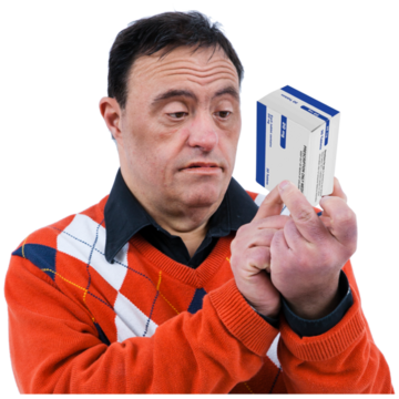 A man is holding up a packet of tablets trying to read the instructions