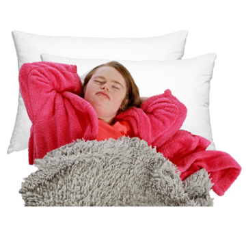 A woman wearing a dressing gown is asleep on two pillows lying under a rug