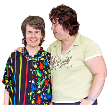 Two people stand together. The person on the right has their arm round the other person's shoulders.
