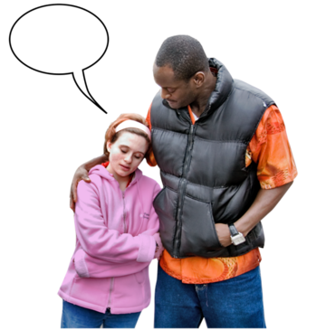A woman with her hands folded standing and talking to her friend. Her friend has his arm around her.