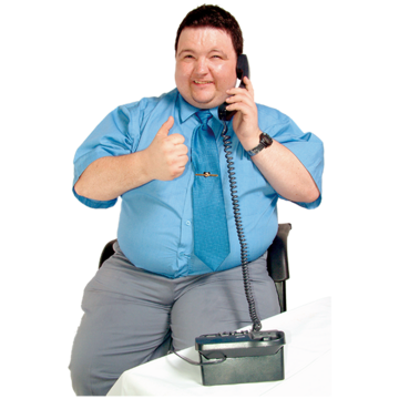 A man sat down on the telephone. He is smiling and is giving a thumbs up sign.