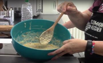 A bowl of fritter mixture and a spoon.