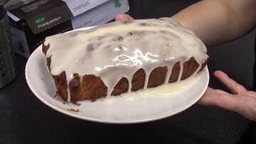 A cake with icing on the top and over the sides.