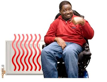 A man in an electric wheelchair in front of a radiator which is on.