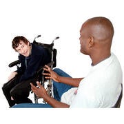 A man in a wheelchair listening to a man sitting on a chair.