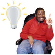 A man in a wheelchair smiling.  Beside him is a light bulb with yellow lines coming out from it.