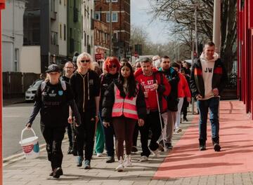 A group of people collecting whilst walking down a street