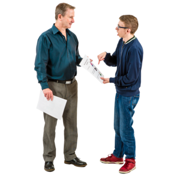 A younger male talking to an older male and pointing at a piece of paper.