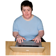 A woman sits at a desk using a laptop