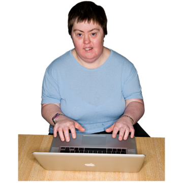 A woman sits at a desk using a laptop