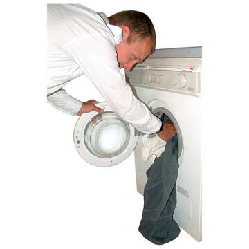 A man putting clothes into a washing machine.
