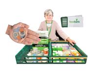 A lady standing behind 2 trays of long life food with a sign that says foodbank and a hand with some coins in it.