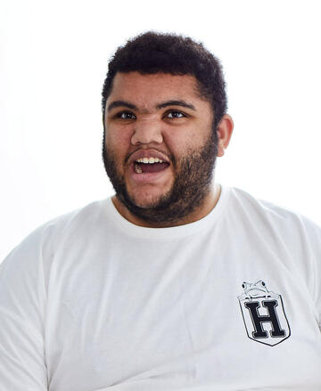 Harvey smiling wearing a white t shirt