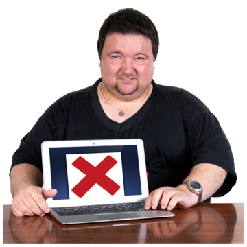 A man sitting at a desk showing a laptop screen with a red cross on it