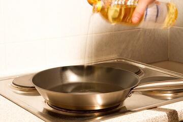 Oil being poured into a frying pan.