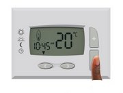 A heating thermostat with a finger on one of the buttons.