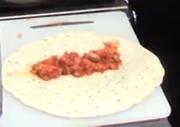A wrap with a line of tomato mixture in the middle.