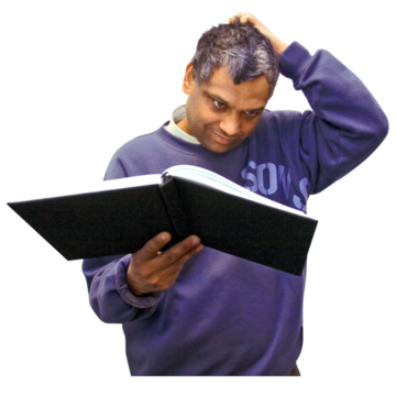 A man is scratching his head reading a book