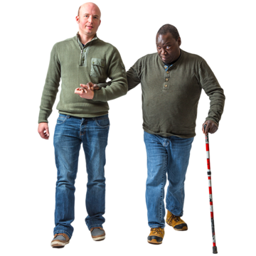 A man is helping another man with a walking stick to walk 