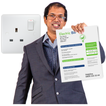 A man standing in front of a plug socket holding an electricity bill and smiling