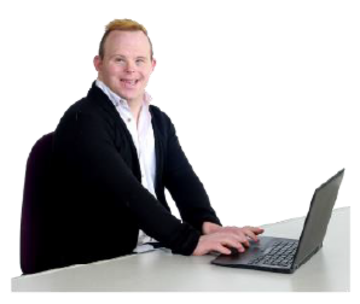 A man sits at a desk using a laptop