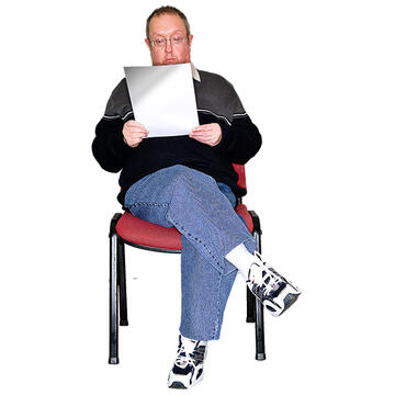 A man sitting on a chair reading.