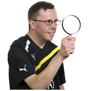 A man is looking through a magnifying glass