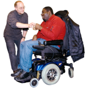 A man is giving a man in a wheelchair a cup of tea