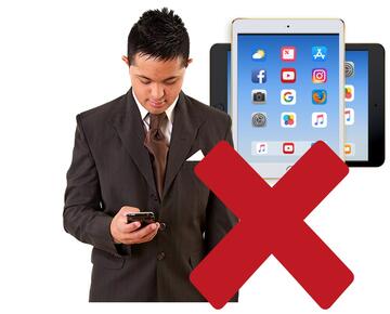 A man looking at his mobile phone and a tablet with a red cross beside them.