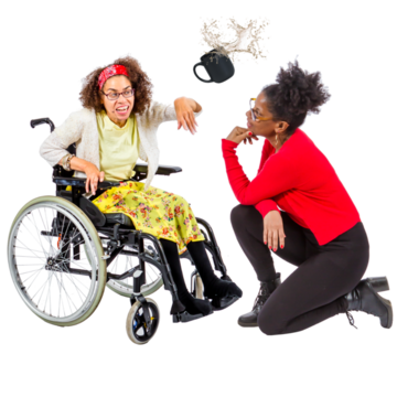 A woman kneels in front of a woman in a wheelchair who is upset and has thrown a mug with liquid in it