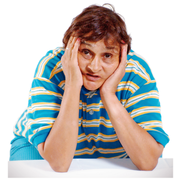 A woman with her elbows on a table and hands holding her head looking fed up