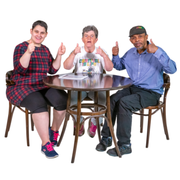 A group of people sitting at a table holding thumbs up