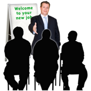A man is holding out his hand in front of three people who are sat facing him. He is next to a flip chart which says Welcome to your new job.