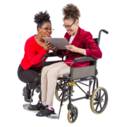 A woman in a wheelchair is being shown a tablet by a support worker who is kneeling down next to her