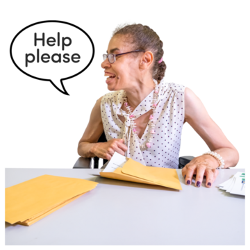 A woman stuffing envelopes at a desk saying "Help please."