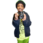 A man smiling and holding up a camera.