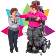 a woman in a wheelchair has her hand on another woman's shoulder. Behind them is a drawing of coloured flower petals
